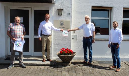 Während seines Besuchs überreicht Wirtschaftsdezernent Dr. Jens Mischak (Zweiter von links) dem Geschäftsführer der Schlitzer Leinen-Industrie Driessen, Helmut Driessen, das Label „Vogelsberg Original“. Will Kreuzer, 1. Stadtrat von Schlitz (links), sowie Wirtschaftsförderer Oliver Rohde gratulierten / Foto: Jennifer Sippel / Vogelsbergkreis