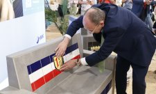 Oberbürgermeister Christian Specht brachte die geflieste Bank beim Eröffnungsrundgang durch die Halle des Handwerks zur Vollendung. / Foto: Handwerkskammer