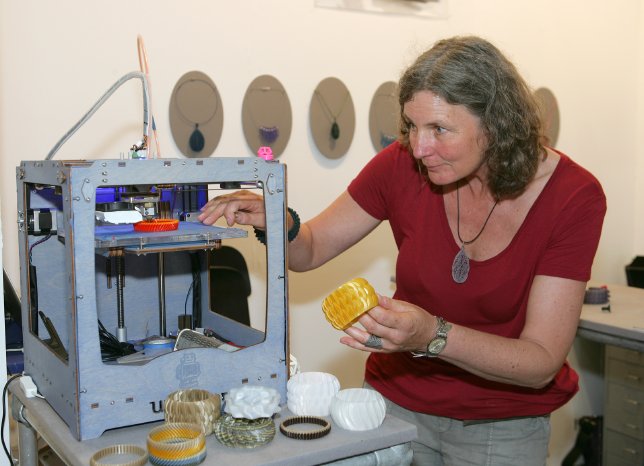 Die Schmuckdesignerin Peggy Bannenberg kontrolliert einen 3D-Druck.jpg