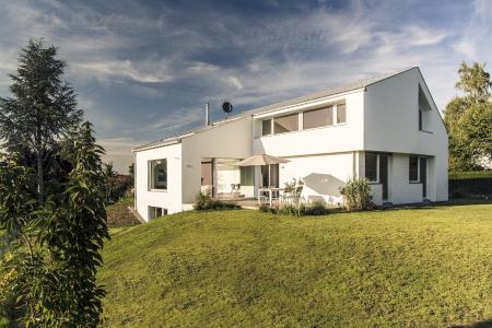 Zum Haus des Jahres 2016 wählten die Mitglieder der in Lüneburg ansässigen Vereinigung 81fünf high-tech & holzbau AG (http://www.81fuenf.de) diesen an den Hang gebauten Holzrahmenbau von Holzbau Fichtl. Die moderne, schneeweiße Fassade des extrem energiesparenden Gebäudes, das dem KfW 40-Standard entspricht, wird allseits von einem INTHERMO Holzfaser-WDVS ummantelt. (Foto: Holzbau Fichtl GmbH, Windach; www.holzbau-fichtl.de)