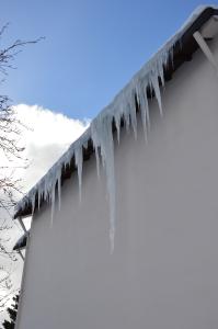 Schöner, aber gefährlicher „Eiszauber“, der durch einen fehlenden Schneefang entstehen konnte. Auch solche Eislasten sollten nur vom Dachdecker sicher entfernt werden