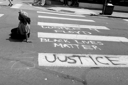 Eine Frau sitzt nach dem Tod von George Floyd bei Protesten in Minneapolis, Minnesota/USA auf der Straße.
© Foto Lorie Shaull / flickr.com