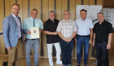 Erster Kreisbeigeordneter Dr. Jens Mischak überreicht Bürgermeister Dieter Schäfer den Bewilligungsbescheid für die Einrichtung des Rundwanderweges „Sieben-Dörfer-Tour“. An der Umsetzung beteiligt sind: Hubert Straub und Reiner Seibert vom Projektteam, Thomas Schaumberg, Geschäftsführer der Vogelsberg Consult, und Peter Sukdolak aus dem Sachgebiet Dorf- und Regionalentwicklung (von links) (Foto: Sabine Galle-Schäfer/Vogelsbergkreis)