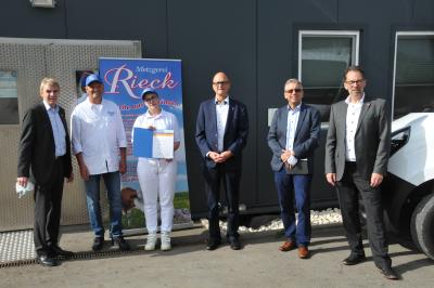 Harald Herrmann, Präsident der Handwerkskammer Reutlingen, Metzgermeister Jochen Rieck, Auszubildende Celina Rösch, Ewald Heinzelmann, Geschäftsführer der Kreishandwerkerschaft Reutlingen und Dieter Laible, Kreishandwerksmeister, bei der Urkundenübergabe vor dem Schlacht- und Produktionsgebäude in Böhringen