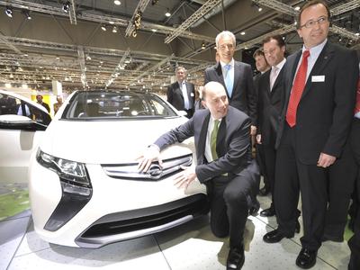 Zu Gast auf dem Opel-Stand bei der AMI Leipzig: Verkehrsminister Wolfgang Tiefensee lädt den elektrischen Opel Ampera, flankiert von Stanislaw Tillich, Ministerpräsident des Freistaats Sachsen (links) und Opel-Vertriebsdirektor Michael Klaus