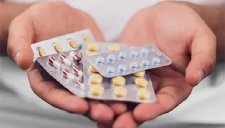 hand mit Tabletten gegen Mundtrockenheit.