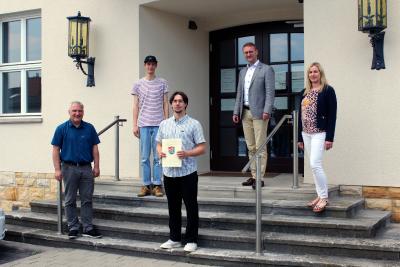 Erster Kreisbeigeordneter Dr. Jens Mischak (CDU, Zweiter von rechts) bei der Übergabe des Förderbescheids an den „klimafairein Oberhessen“. Katharina Barth vom Verein Region Vogelsberg (rechts) und Peter Sukdolak vom Amt für Wirtschaft und den ländlichen Raum (links) begleiteten das Antragsverfahren und ermöglichten den Förderbescheid, den Marcel Rossol (vorne) und Simon Bast vom „klimafairein“ nun entgegennehmen konnten. (Foto: Vogelsbergkreis/C.Lips)