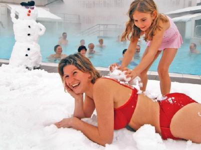 Belebendes Schneebad in den Thermen: Erst ein erfrischendes Schneebad, dann hinein in das wohlig warme Thermalwasser: für die Gäste in den Bad Füssinger Thermen ist diese Schnee-Thermen-Kneippkur ein ganz besonderes Badevergnügen - eine belebende Attraktion, die nur der Winter bietet. Foto: Kur- & GästeService Bad Füssing