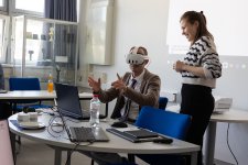 Projektmitarbeiterin Finja Wegener von der TH Lübeck zeigt Minister Schrödter einen Prototyp für eine Anwendung im Projekt. Durch die VR-Brille sieht man Sensordaten, wie zum Beispiel Temperaturdaten, die im Raum visualisiert werden