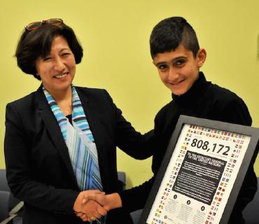 Der 12-Jährige Noeh übergibt die Petitionsurkunde an Kyoko Shiotani, Leiterin des Büros des Untergeneralsekretärs der Vereinten Nationen / © Foto: Open Doors