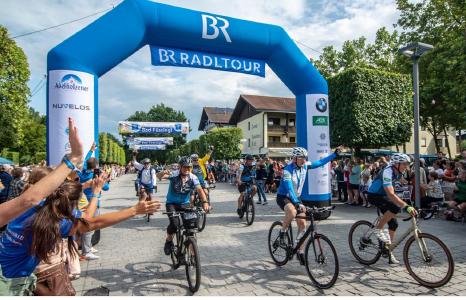 Begeisterter Empfang für die mehr als 1.500 aktiven Radler auf der Schlussetappe der 30. BR-Radltour am Ziel in Bad Füssing. Foto: obx-news/ BR/Philipp Kimmelzwinger