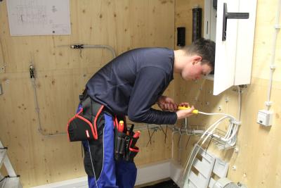 Thomas Schönliner, Sieger des Nationalwettbewerbs Anlagenelektrik, von der Milchwerke Berchtesgadener Land Chiemgau eG aus Piding ist konzentriert auf das Verlegen von Stromkabeln zum Schaltschrank.