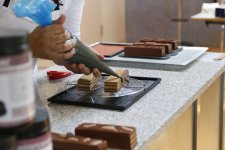 Laurent Massé verziert kunstvoll ein Törtchen seiner mitgebrachten Rezepturen im Herbert-Gutfleisch-Saal der Bildungsakademie der Handwerkskammer / Foto: Handwerkskammer