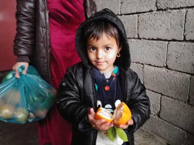 Dieses jesidische Flüchtlingskind im Nord-Irak freut sich über das frische Obst aus der ersten Verteilaktion von Shelter Now