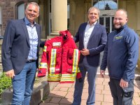 Die Geschäftsführer Prof. Dr. Michael  Geißler und Markus Heming übergeben die Einsatzkleidung an Dr. Björn Bergau, Bild: Markus Kümmerle, Städtisches Klinikum Karlsruhe