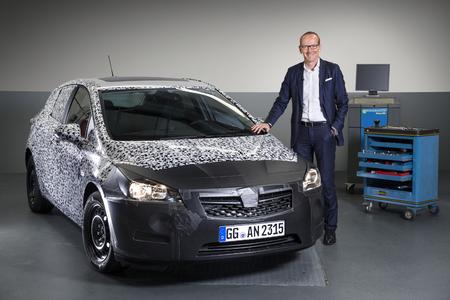Stolzer Moment: Opel-Chef Dr. Karl-Thomas Neumann präsentiert einen noch stark getarnten Astra-Prototypen der neuen Generation. Foto Opel AG