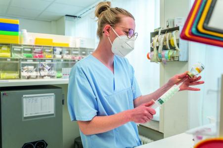 Krankenschwester zieht ein Medikament mit Spritze auf