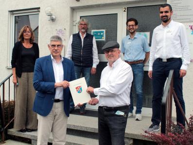 Landrat Manfred Görig überreicht Frank Gebauer im Beisein von Monika Jurkowitsch und Matthias Gold (Beratungszentrum), Simon Päbler (Sachgebiet Sozialer Dienst) und René Lippert, dem Leiter des Sozialamtes, (von links) die Zuwendung des Vogelsbergkreises in Höhe von 220.000 Euro / Foto: Sabine Galle-Schäfer/Vogelsbergkreis