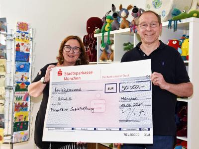 Max Straßer von der Findelkind-Sozialstiftung überreicht Jacqueline Flory, der Gründerin des Vereins "Zeltschule e.V."den Spendenscheck über 50.000 Euro