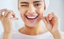 Frau, die Zahnseide benutzt.