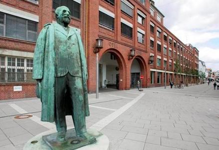 Industrie-Denkmal: Adam-Opel-Statue vor dem Hauptportal des historischen Opelwerks im Zentrum von Rüsselsheim