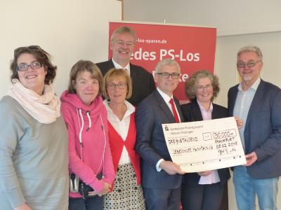 Gerhard Grandke, Geschäftsführender Präsident des Sparkassen- und Giroverbandes Hessen-Thüringen, und Oliver Klink, Vorstandsvorsitzender der Taunus Sparkasse, übergeben den Spendenscheck an die Vertreter der Lebenshilfe Main-Taunus