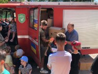 Übergabe der Hilfsgüter im Waisenhaus in Krementschuk: Gemeinsam mit den Mitarbeitenden des Waisenhauses werden die mit der Feuerreer transportierten Sachspenden entladen. Neben technischen Hilfsmitteln umfasst die Lieferung auch zahlreiche reer Produkte wie Kindergeschirr, Babyphone, Nachtlichter und Fieberthermometer, die den Alltag der Kinder und ihrer Betreuer erleichtern sollen.