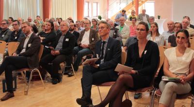 Dr. Elisa Stickler und Maria Münzel informierten beim Vogelsberger Gesundheitsforum über das Projekt „Gemeindeschwester 2.0“. Moderiert wurde der Abend von Ulf Werner (OptiMedis AG), begrüßt wurden die Gäste von Erstem Kreisbeigeordneten Dr. Jens Mischak (erste Reihe, von rechts). Foto: Sabine Galle-Schäfer/Vogelsbergkreis