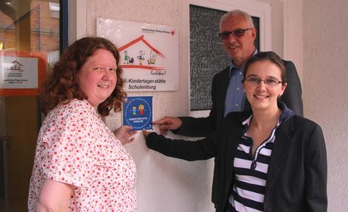 DRK-Kita Schulenburg zertifiziert: Erwin Jordan, Dezernent für soziale Infrastruktur der Region Hannover, Ramona Schumann, Bürgermeisterin von Pattensen, und Kita-Leiterin Ilka Dangl bei der Übergabe der Plakette (v.l.n.r.).