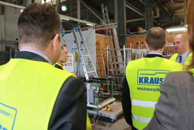 Abteilungsleiter Jürgen Steinbrecher (hinten rechts) erklärt den Produkttest der Stehleiter im Hintergrund: Etwa eine Woche lang steht sie auf unebenem Grund und wird mit 150 kg Gewicht wechselseitig 50.000 mal „betreten“!, Foto: Gaby Richter