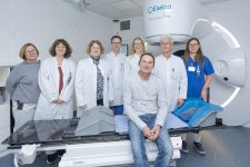  Das interdisziplinäre Team um Prof. Katja Lindel (3.v.l.), Prof. Armin Luik (4.v.l.), Dr. Antje Wark (3.v.r.) und Prof. Julian Widder (2.v.r.) mit einem Patienten (sitzend auf dem Linearbeschleuniger).