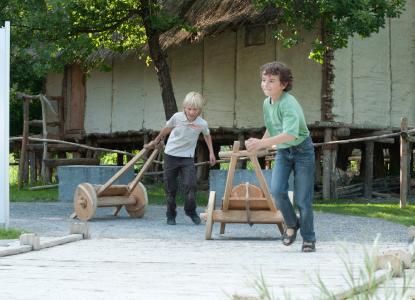 Mit hölzernen Wagen in Kleinformat werden bei der Steinzeit-Olympiade Runden gedreht. Copyright Pfahlbaumuseum Unteruhldingen, einmaliger Abdruck frei
