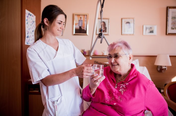 Berliberlinski Pflegerin und Bewohnerin mit Wasserglas Senioren-Zentrum Nittenau DSC0213.jpg