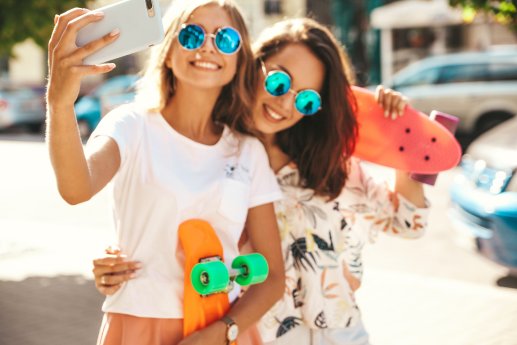two-young-female-stylish-hippie-brunette-blond-women-models-summer-hipster-clothes-taking-selfie.jpg