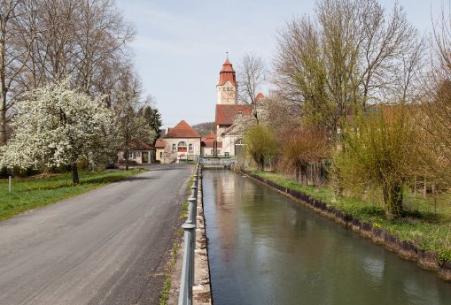 Firmensitz in Bempflingen 2025 mit Wasserlauf Solaranlage auf Dach des Hochbaus rechts teil.jpg