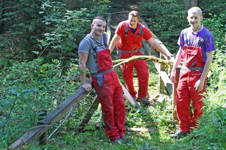 Marc Bischof, Dominic Unverhaun und David Eichhorn (von links nach rechts) von der Jugendwerkstatt Osterode an der Holzbrücke im Großen Engelntal im Niedersächsischen Forstamt Riefensbeek