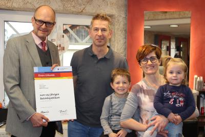 Hauptgeschäftsführer Dr. Joachim Eisert bei der Überreichung der Ehrenurkunde an Oliver Stumpp sowie Ehefrau Karin mit Kindern