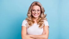 Blonde Frau mit Brille die lächelt.