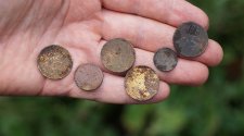 Hand mit rostigen, alten Münzen.
