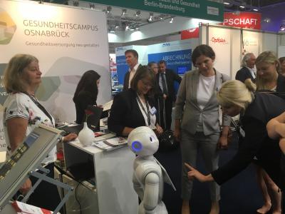 Neben vielfältigen wissenschaftlichen Beiträgen und Projektvorstellungen zog das „Pepper“-Modell namens „Lou“ am Stand des GCO die Blicke auf sich. Der Roboter des Instituts für Kognitionswissenschaft lud zu einem Quiz ein, bei dem Besucherinnen und Besucher ihr Wissen zum deutschen Gesundheitswesen auf die Probe stellen konnten
