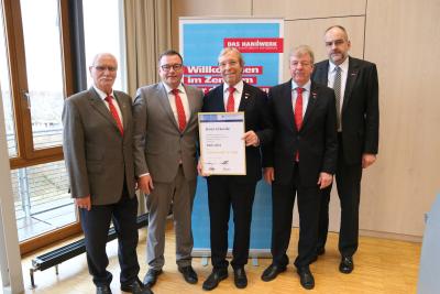 Nach der Verleihung der Goldenen Ehrennadel stellten sich Präsident Alois Jöst (Mitte), Vizepräsident Arbeitgeberseite Klaus Hofmann (2. v. links), Vizepräsident Arbeitnehmerseite Martin Sättele (2. v. rechts), Hauptgeschäftsführer Jens Brandt (rechts) und Ehrenvizepräsident Gerhard Höfler (links)zusammen dem Fotografen / Bildquelle: Handwerkskammer Mannheim