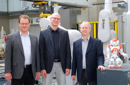 Drei Professoren und ein Nao im Robotiklabor: Prof. Dr. Dirk Rokossa, Prof. Dr. Siegmar Lampe und Prof. Dr. Clemens Westerkamp, Sprecher (v.l.) leiten das neu gegründete Kompetenzzentrum „I4os - Industrie 4.0 Osnabrück" an der Hochschule Osnabrück / Foto: Hochschule Osnabrück