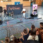 Gespannt verfolgen die Schülerinnen und Schüler der Grund- und Mittelschule Bergkirchen die Konzertlesung von Jana Crämer (rechts) und Batomae (Mitte), die von der BKK ProVita im Rahmen von „BKK bauchgefühl“ ermöglicht wurde.