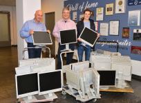 Peter Kraus (Leiter IT.Services, li.) und Dr. Gunther Schunk (Chief Communication Officer, mi.) von Vogel Business Media übergeben 41 Monitore an Moritz Beck, Vorstandsvorsitzender 