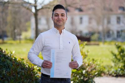 Faruk Güler, geboren und wohnhaft in Wertheim am Main, freut sich, seine Bachelorurkunde in Händen zu halten
