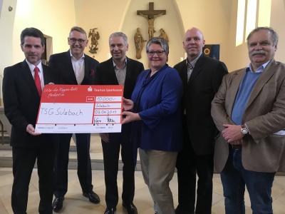 v.l.n.r.: Eric Hemmerling, Leiter der Filiale Kelkheim der Taunus Sparkasse, Markus Franz, Mitglied des Vorstands der Taunus Sparkasse, und Landrat Michael Cyriax übergeben den Spendenscheck an Inge Rohs, 1. Vorsitzende der TSG Sulzbach, Malte Kunga, 2. Vorsitzender, und Abteilungsleiter Volkhard Schlotte.