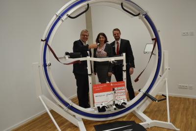 v.l.n.r.: Landrat Ulrich Krebs, stellvertretender Vorsitzender des Kuratoriums der Gemeinnützigen Stiftung der Taunus Sparkasse, Dr. Claudia Müller-Eising, Geschäftsführerin von Neuroneum, und Frederik Zölls, Marktbereichsleiter der Taunus Sparkasse im Hochtaunuskreis, freuen sich über die Anschaffung des "Spacecurl"