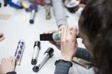 Eine Schülerin blickt durch ein Kaleidoskop 