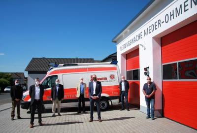 „Gemeinsam, aber geschützt und auf Abstand“ (v.l.n.r.: Bürgermeister Andreas Sommer, Landrat Manfred Görig, Landesvorstand Oliver Meermann, Johanniter-Unfall-Hilfe e.V. (JUH) Landesverband Hessen/Rheinland-Pfalz/Saar, Helmut v. Schenk zu Schweinsberg, ehrenamtlicher Regionalvorstand JUH Regionalverband Mittelhessen, Marco Schulte-Lünzum, Regionalvorstand JUH Regionalverband Mittelhessen, Architekt Gerhard Schymik sowie Ortsvorsteher Jörg Matthias.) Foto: Miriam Julia Feuerstein/JUH
