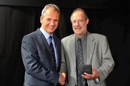 Michael Wendt (l.), Vorsitzender der Geschäftsführung Pirelli Deutschland, gratuliert Ludwig Ruppert zu seinem 50-jährigen Firmenjubiläum